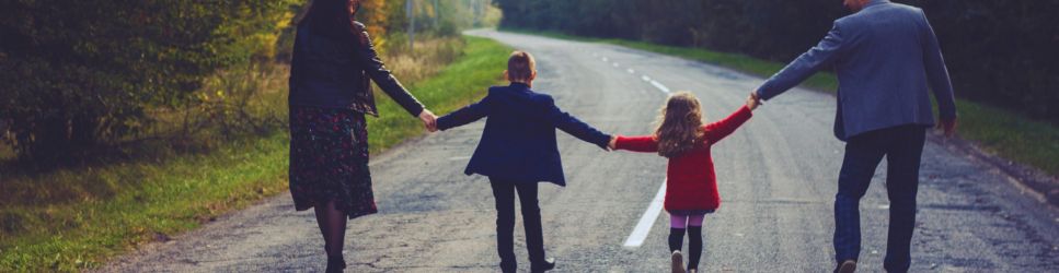 An image of a family holding hands on a winding road for the Family Law web header